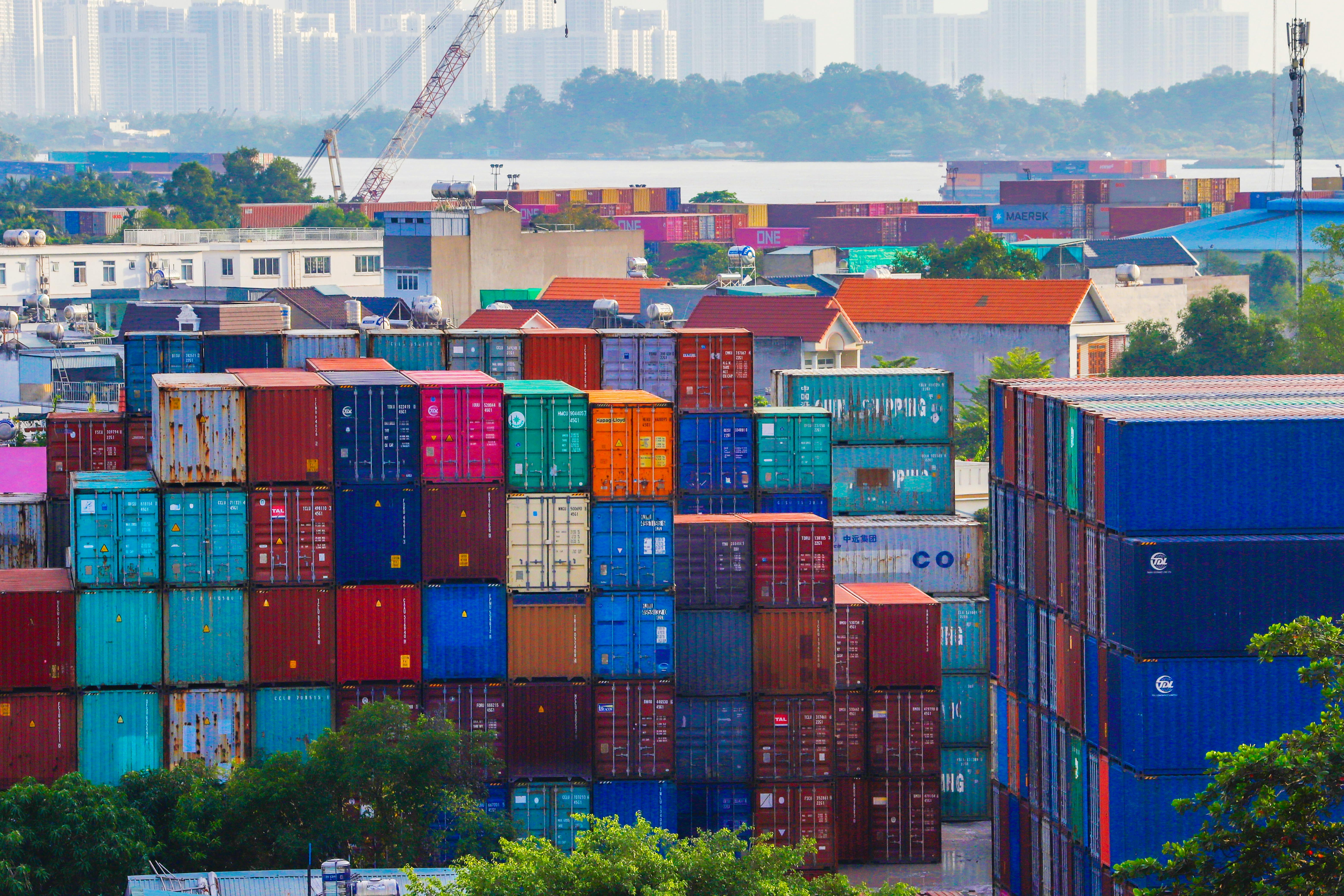 Colorful shipping containers stacked at a port. The complexity of global trade compliance