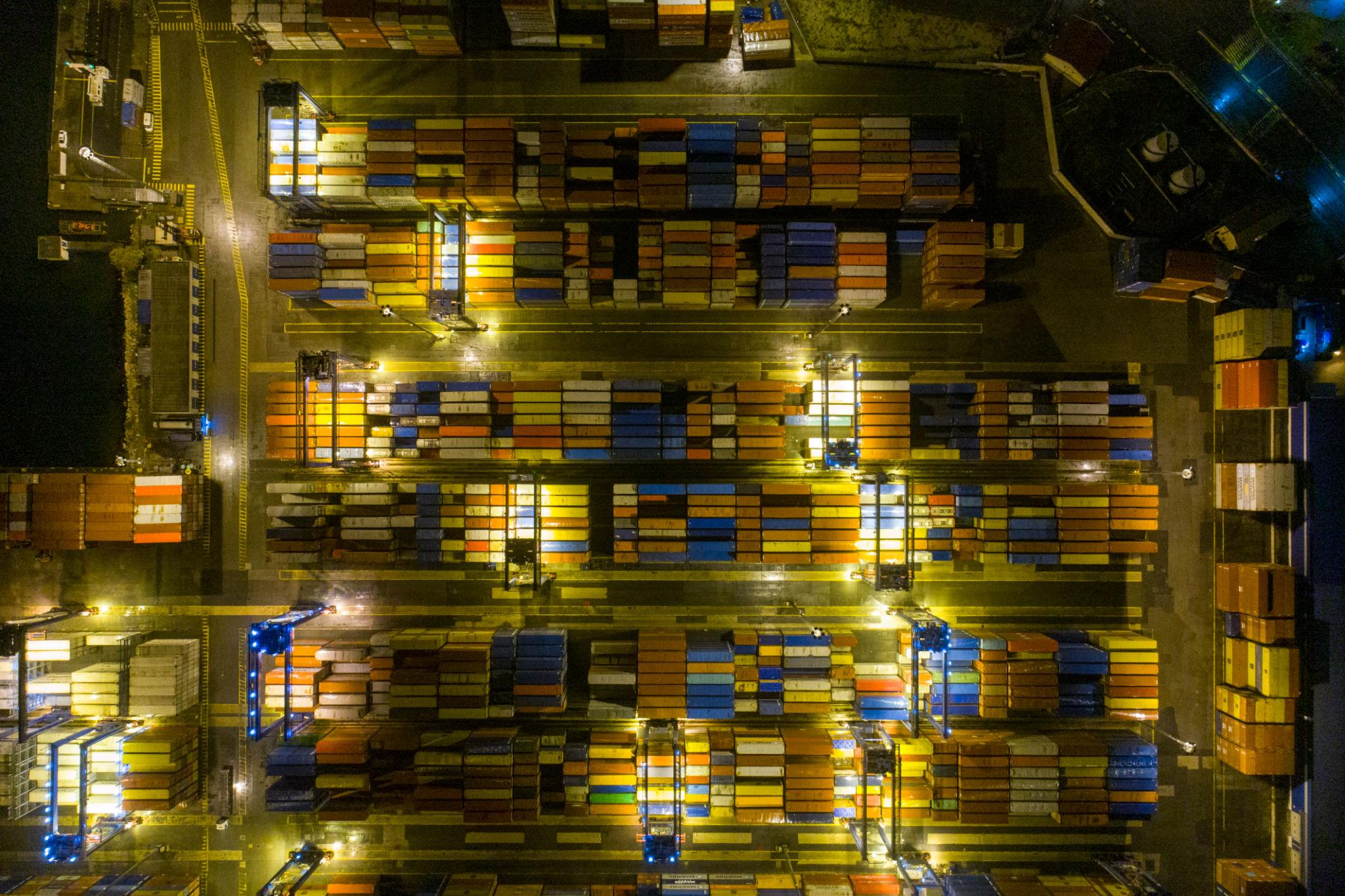 Aerial view of container port at night, global trade infrastructure