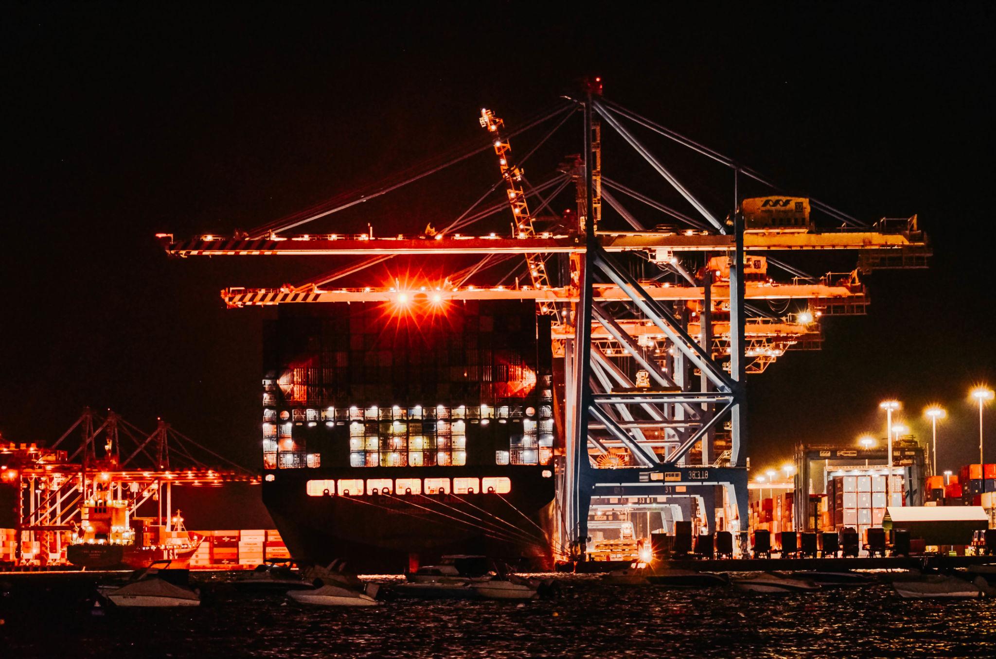 Container ship at night port terminal. The scale of global trade infrastructure